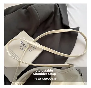 Close-up of beige crocodile pattern bag with silver hardware and adjustable strap
