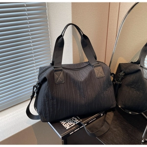 Detail view of black textured large capacity tote bag with reinforced handles and strap