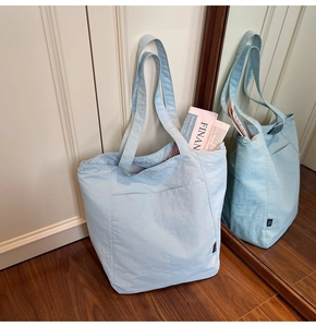 Detail of light blue tote bag showing the side view and textured fabric in a mirror reflection