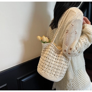 Detailed close-up of cream handmade crochet bucket bag with hollow diamond pattern