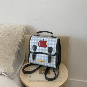 Dettaglio mini zaino a scacchi blu con toppa a mela rossa ed etichetta Not Anxious