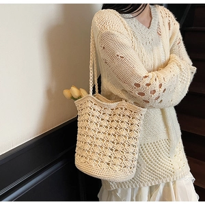 Detail of hand-woven cream crochet shoulder bag with hollow wave pattern and inner liner