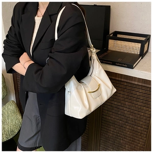 Détail du sac hobo plissé blanc avec boucle en métal doré sur une bandoulière