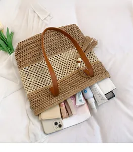 Dettaglio della capiente borsa tote in paglia bicolore con manici in pelle e ampio spazio interno