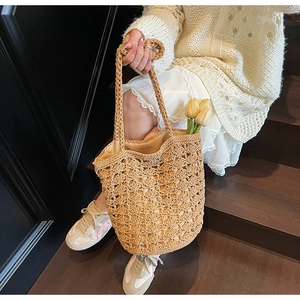 Detail of straw tote bag showing hollow-out woven texture and light beige inner lining