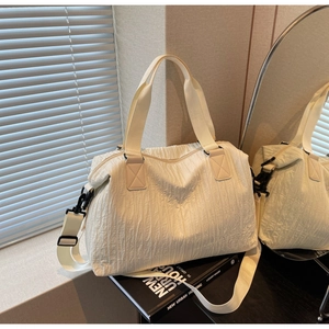 Detail of the vertical pleated texture and sturdy carrying straps on the cream canvas tote