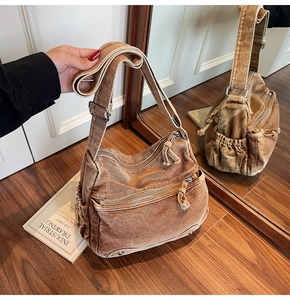 Detail of vintage brown washed canvas crossbody bag with multi-pocket design and strap