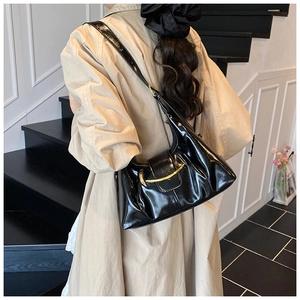 Détail d'un sac à bandoulière en similicuir plissé noir avec garniture dorée élégante
