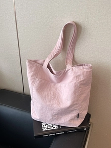 Light pink nylon tote bag with wide shoulder straps for daily commuting and office use