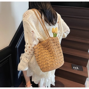 Detail of hand-woven straw tote bag with hollow floral pattern and tulip decoration