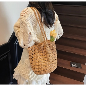 Detail of hand-woven straw tote bag with mesh hollow design and neutral inner lining