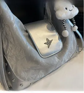Détail du sac argenté en tissu plissé avec étoile métallique et pendentif nuage doux