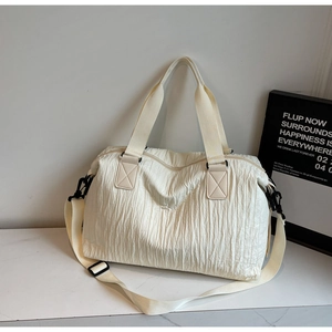 Detail of off-white wrinkled canvas tote bag showing black metal hooks and strap