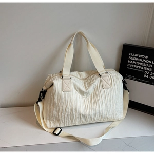 Detail of off-white large canvas tote featuring unique vertical pleated texture and strap
