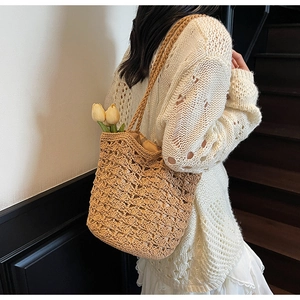 Close-up of a handwoven straw bucket bag with hollow texture and beige fabric lining