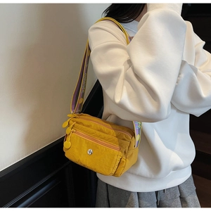 Detail of yellow nylon crossbody bag with purple SJCHAO embroidered strap and multi-pockets
