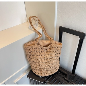 Detail shot of hollow crochet weave pattern on a khaki straw beach bucket bag