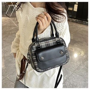 Close-up of vintage check pattern texture and black leather stitching detail