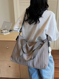 Large taupe pleated canvas tote bag with adjustable crossbody strap and wide handle