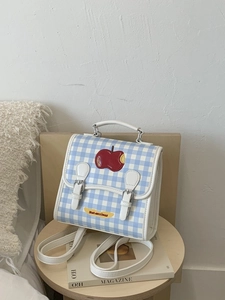 Zaino a scacchi blu con ricamo a mela su sgabello in legno per un look alla moda