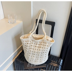 Detailed close-up of a cream crochet tote bag with hollow fan patterns and cloth liner