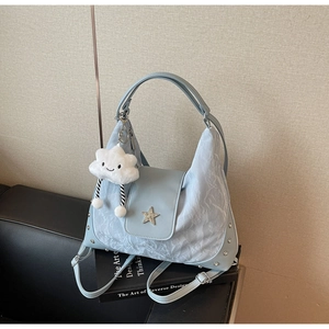 Détail du sac hobo bleu clair avec ornement étoile, clous en métal et pendentif nuage