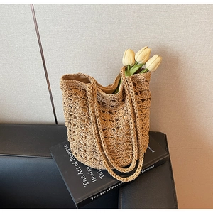 Detailed close-up of handmade hollow-out crochet straw shoulder bag with beige fabric lining
