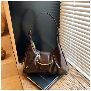 Gros plan d'un sac à main marron foncé brillant avec boucle en métal doré élégante