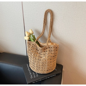 Detail of hand-woven straw tote with hollow-out texture and fabric lining for beach use