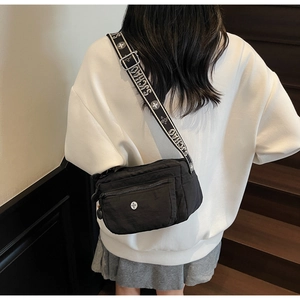 Model view of black nylon crossbody bag with patterned adjustable wide shoulder strap