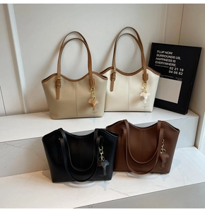 Detailed view of four retro leather tote bags in beige, cream, black and brown with elephant charms