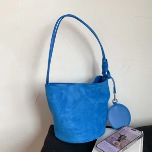 Detail view of Klein blue suede bucket bag featuring a unique knotted shoulder strap