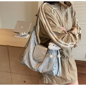 Détail du sac argenté métallisé avec strass en étoile et breloque nuage en peluche