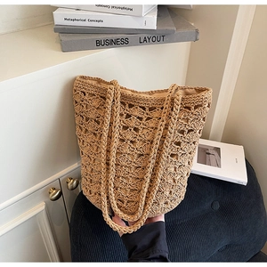 Detailed view of beige straw bucket bag featuring intricate hollow weave and fabric lining