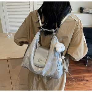 Détail du sac cabas plissé argenté avec étoile métallique et breloque nuage doux