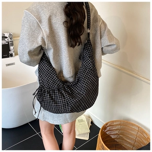 Detail of checkered hobo bag showing large capacity and adjustable wide strap on model