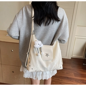 Vue de dos d'un modèle portant un grand sac hobo beige avec étoile et nuage en peluche