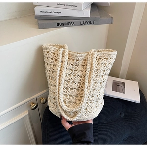 Close-up of cream handmade woven tote bag featuring an intricate hollow crochet pattern