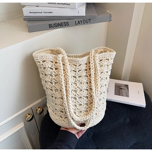Detailed view of the intricate crochet pattern and sturdy fabric lining of the straw tote bag