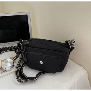 Detail of black nylon crossbody bag with multi-zipper pockets and jacquard strap