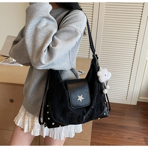 Détail du sac plissé noir avec emblème étoile argentée et charme nuage en peluche
