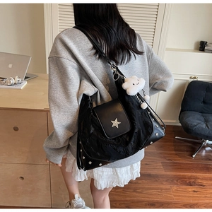 Détail du sac cabas noir avec boucle étoile argentée et ornements de rivets