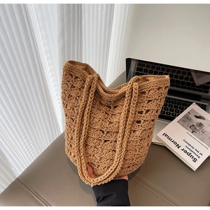 Close-up of handmade straw bucket bag with intricate openwork weave and shoulder strap