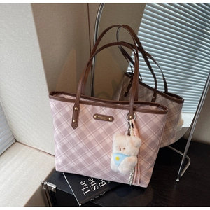 Détail du sac cabas à carreaux roses avec anses en cuir marron et breloque ours blanc
