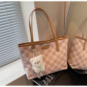Détail du sac cabas à carreaux roses avec poignées en cuir marron et ours en peluche