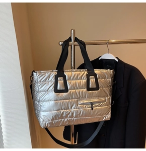 Détail du grand sac cabas argenté matelassé avec poignées en sangle noire robuste
