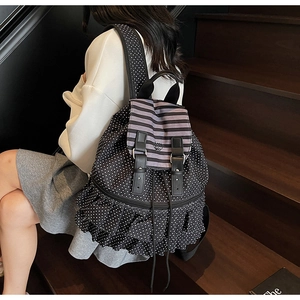 Detail eines Damen-Rucksacks mit Polka-Dots, Rüschen-Elementen und gestreifter Klappe