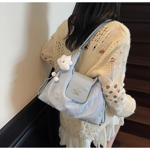 Détail du sac en nylon bleu clair avec boucle étoile en métal et breloque nuage doux