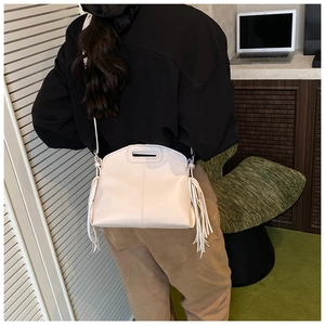 Detailed view of white PU leather tote bag with stylish fringe and unique cutout handle