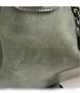 Macro shot of dark green tote bag showing detailed soft grain texture and leather finish